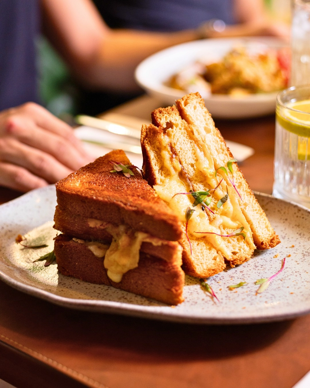 Toasted sandwich with melted cheese served on a brunch plate.